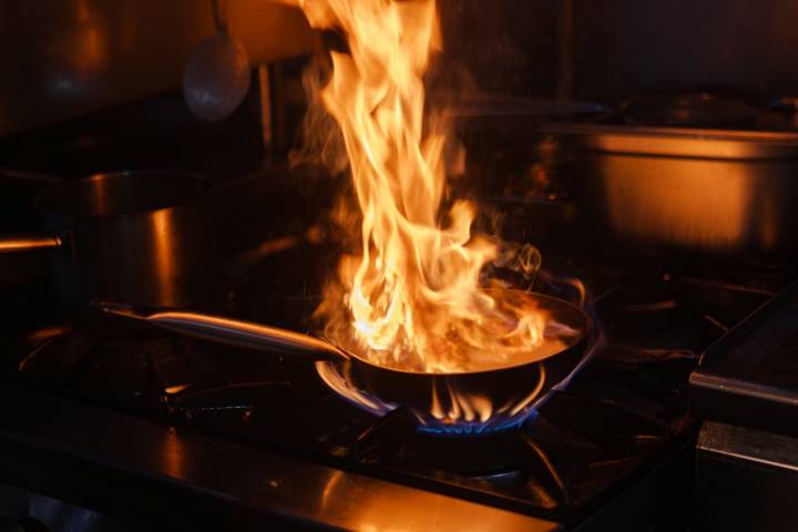 El chef domina el fuego en la cocina.
