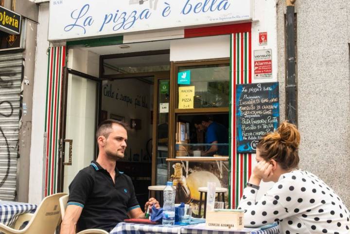 La terraza del 'La pizza è bella', en Madrid, con clientes sentados a sus mesas.