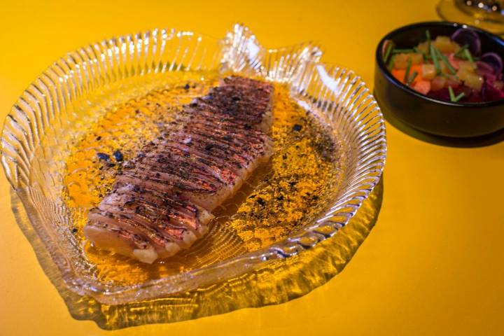 El salmonete con encurtidos se calienta en el mismo plato con un soplete.