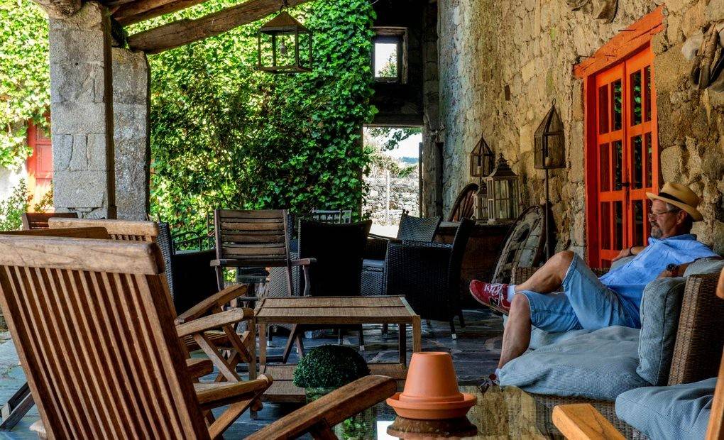 Persona sentada en la terraza de un pazo reconvertido en un hotel rural. Foto: Casa Grande de Rosende.