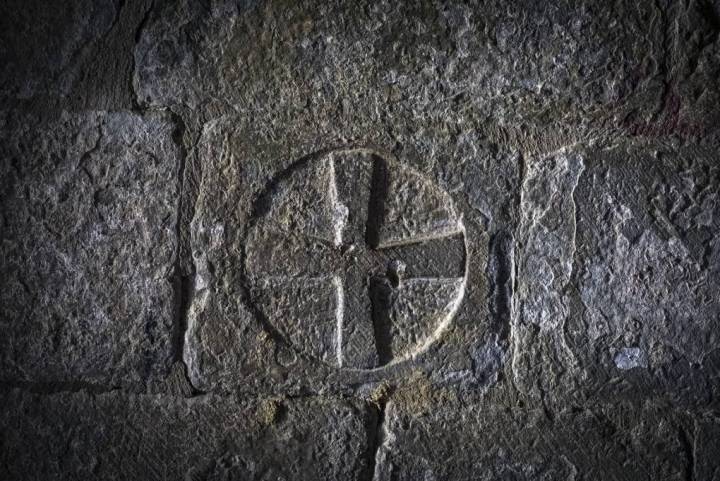 Cruz tallada en una de las piedras del pasaje que lleva a la iglesia de San Esteban.