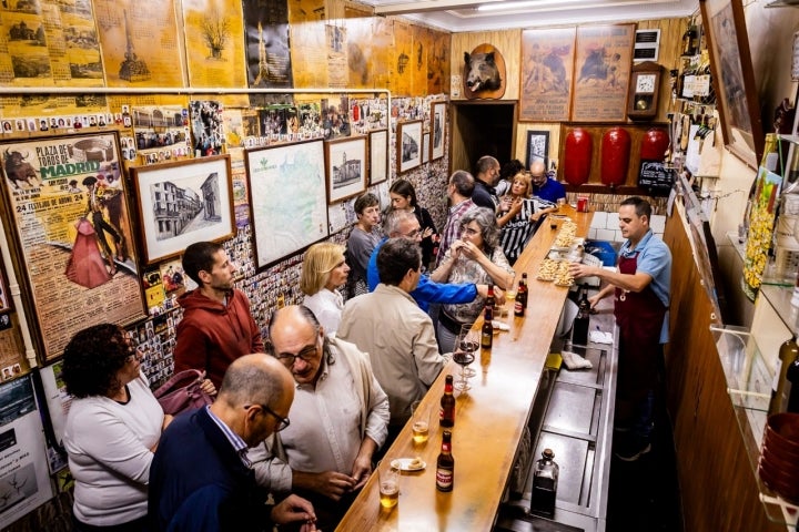 La cabeza de un jabalí, un cartel con errata y un reloj de péndulo dominan la pared del fondo
