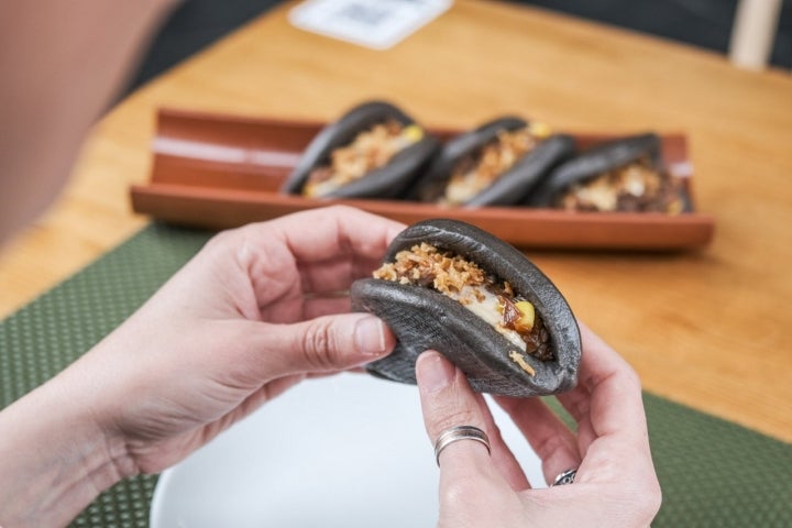 Los Black Bao de 'Casco Viejo' se sirven con carrillera de cerdo deshilachada, BBQ coreana, maíz dulce, emulsión de soja dulce y cebolla frita.