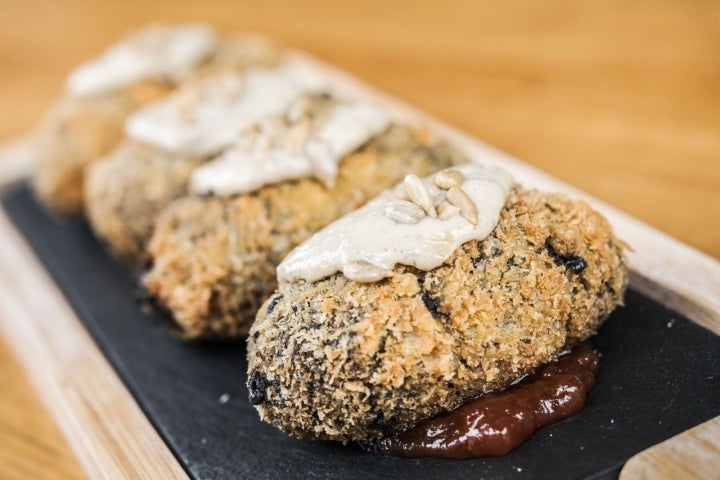 Papá Croqueta del local en Talavera de la Reina 'Casco Viejo': son unos croquetones de chipirón en su tinta y puerros servidos sobre una cama de mermelada de tomate y pipas fritas.