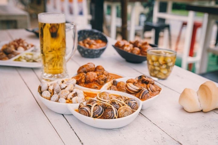 Plato degustación de Noreña con cabrillas con gulas, con rabo de toro, caracoles al picantón y gordos con salsa tradicional.