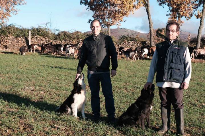 Adrián y su hijo Rubén posan con las perras que les ayudan a pastorear.