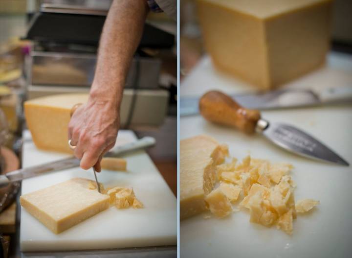 Raúl astillando un queso parmesano con cuchillo corto tipo estilete.