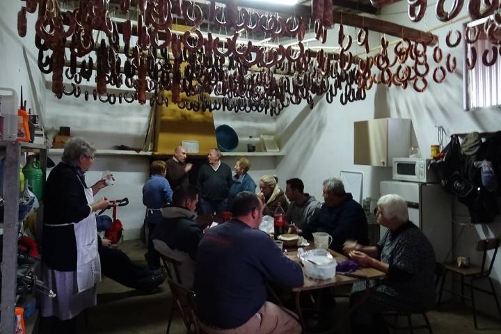La familia durante el momento de descansar y tomar energías comiendo las clásicas migas, durante la matanza del cerdo ibérico, en la comarca de Los Barros (Badajoz).