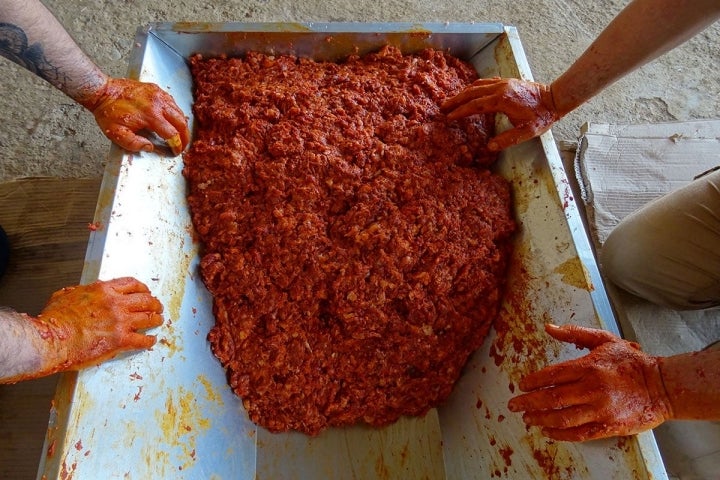 La carne picada mezclada con el pimentón De La Vera, durante la matanza del cerdo ibérico, en Badajoz.