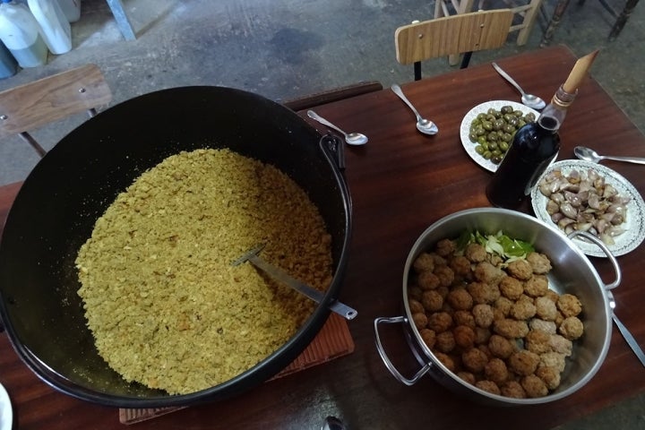 La mesa puesta con la olla de migas, aceitunas y vino de pitarra durante la matanza del cerdo ibérico, en la comarca de Los Barros, Badajoz.