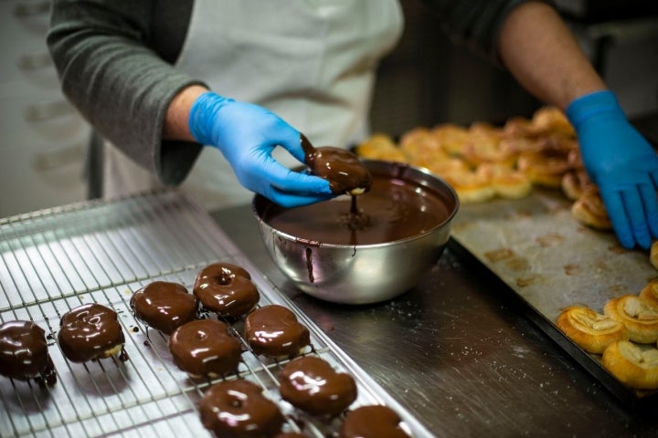 Las palmeritas se sumergen una a una en el chocolate aún caliente. Irresistibles...