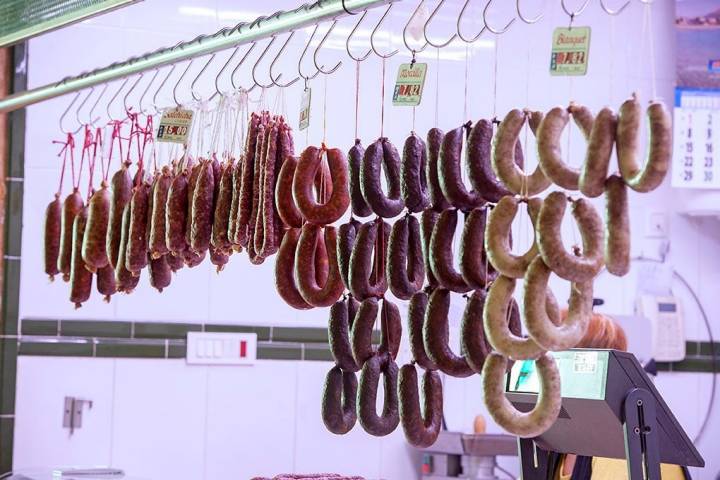 Chorizos, longanizas, sobrasadas, 'blanquets' y morcilla de Xàbia cuelgan sobre el mostrador de 'Castelló'.
