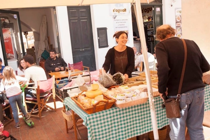 Antonia Taltavull atiende su puesto de quesos y embutidos en el Mercat Agrari, en Ciutadella.