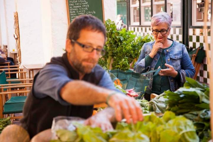 Ignasi atiende el puesto de verduras y frutas ecológicas en el Mercat Agrari en Ciutadella.