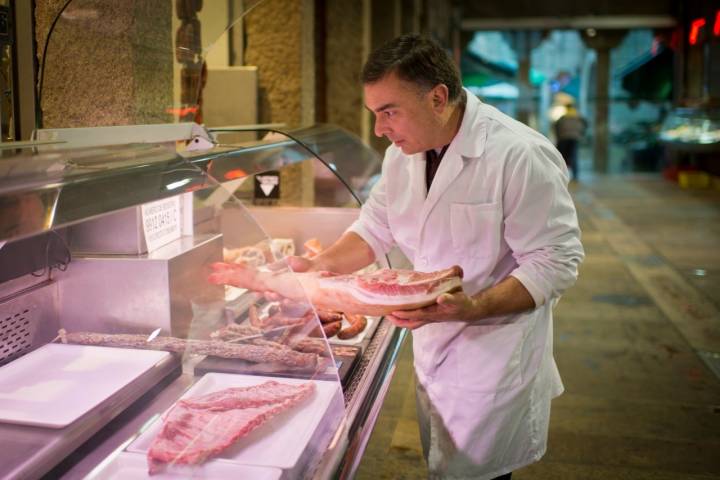 A primerísima hora de la mañana, Manuel coloca las carnes en el mostrador.