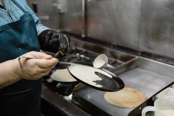 Echando una fina capa de mezcla en la sartén de las filloas.