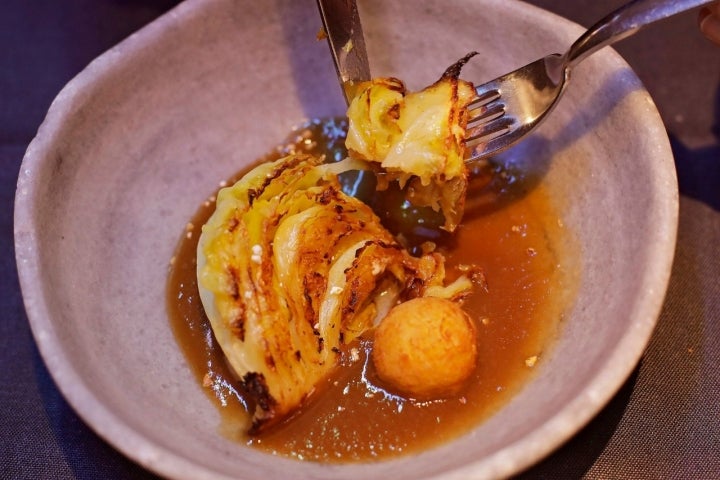 Berza asada con caldo de jamón y croqueta de 'kimch'.