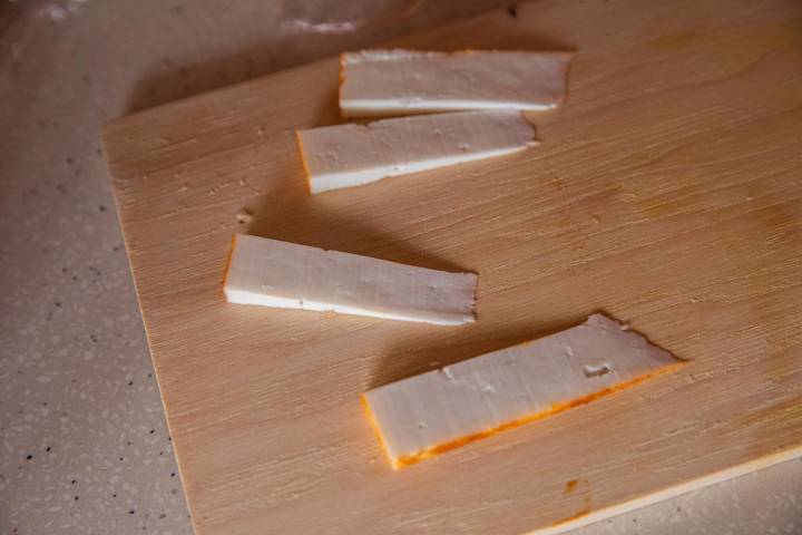 Varios trozos de queso sobre una tabla de madera.
