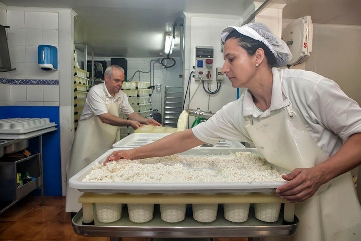 Juan Carlos y Visi rellenan los moldes con el cuajo de los quesucos.