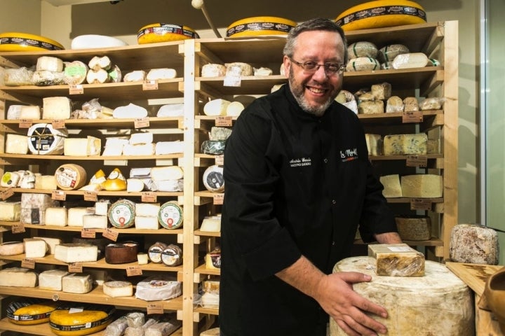 Andrés García rodeado de los quesos curados de la cava.