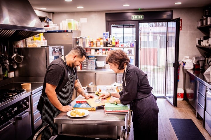 Melania Lourdes y Cristian consultan libros de cocina.