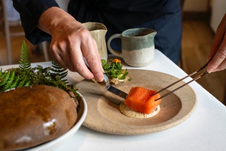 Trucha del río Bedón en su propio hábitat de raíces, musgo y hojas secas del restaurante Casa Marcial (Asturias).