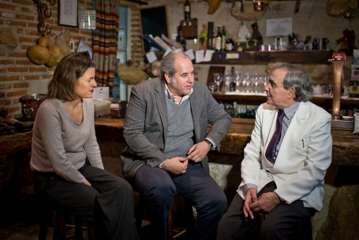 Pedro Guiñales, su hija Irene y Luis Suárez de Lezo charlan en la centenaria bodega.