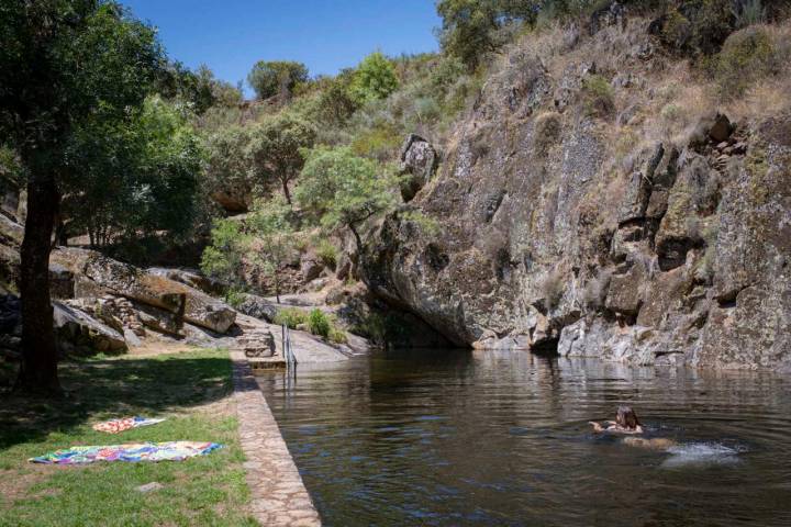 La imponente roca de la montaña hace de pared natural de la piscina.