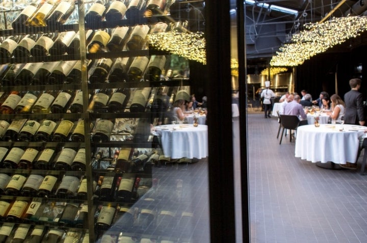 La bodega del restaurante se integra en un cubículo de cristal que separa la zona de bar de las cocinas.