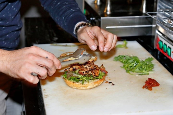 'Pane e porchetta' con salsa 'sriracha' y salsa 'perrins', queso 'scamorza' fundido y desengrasado, ensalada, tomate seco y hierbabuena.