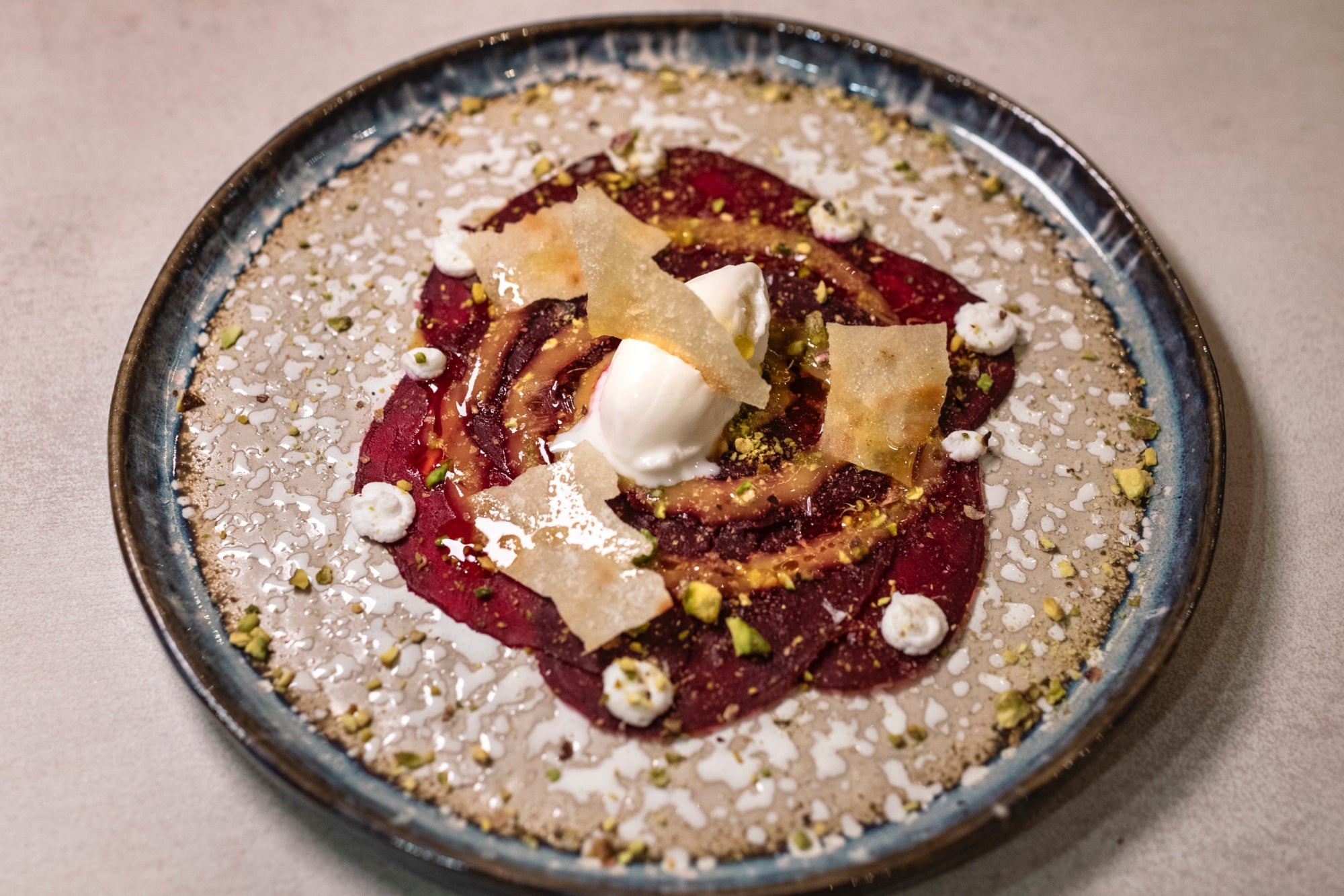 El carpaccio de remolacha, vinagreta francesa, pistacho y helado de cabra.