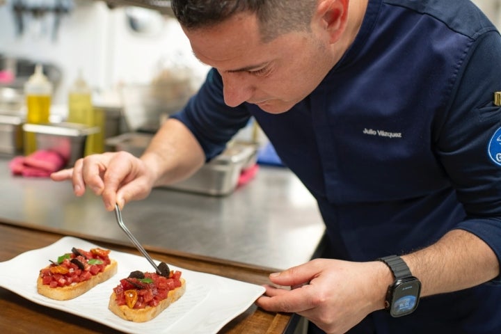 Julio emplatando la tosta de atún en cocina.