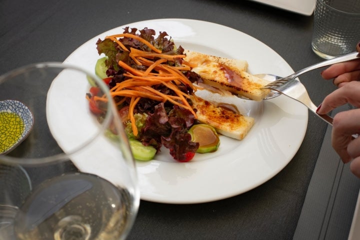 Ensalada de temporada con queso fresco de cabra flambeado y vinagre de ciruela.