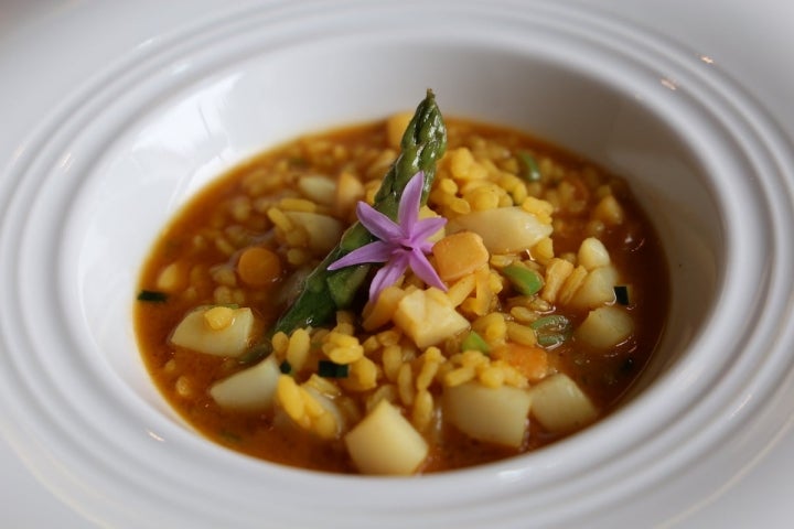 Arroz caldoso de vieira con flor de ajo y triguero.