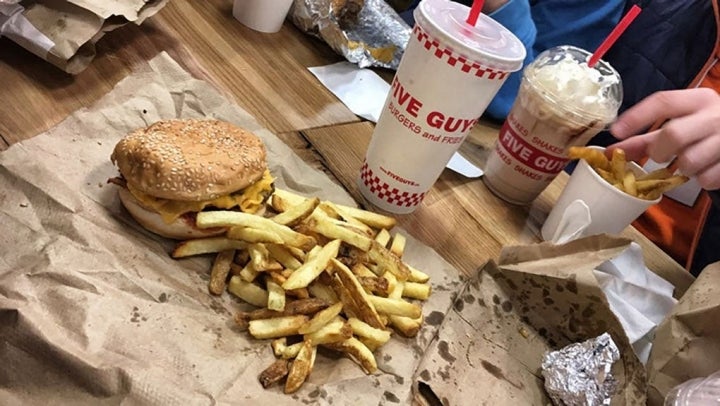 La hamburguesa y las patatas junto a un refresco y un batido.