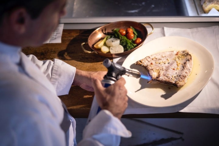 El chef termina un pez limón en La Taberna de Mike Palmer (Málaga).