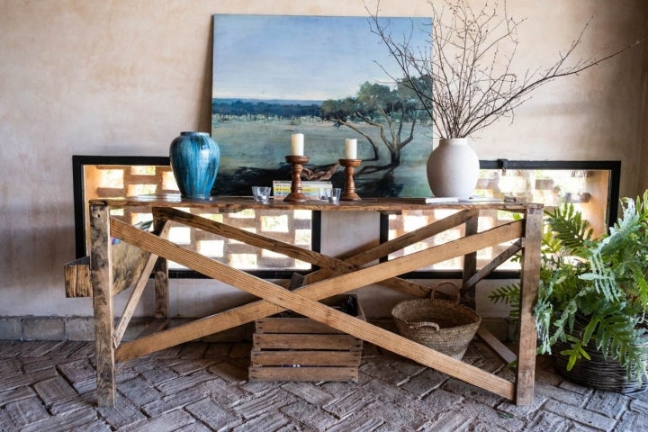 Una mesa con candelabros y un cuadro al fondo. 