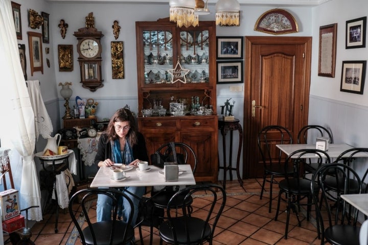 Una mujer desayuna en la sala de la pastelería.