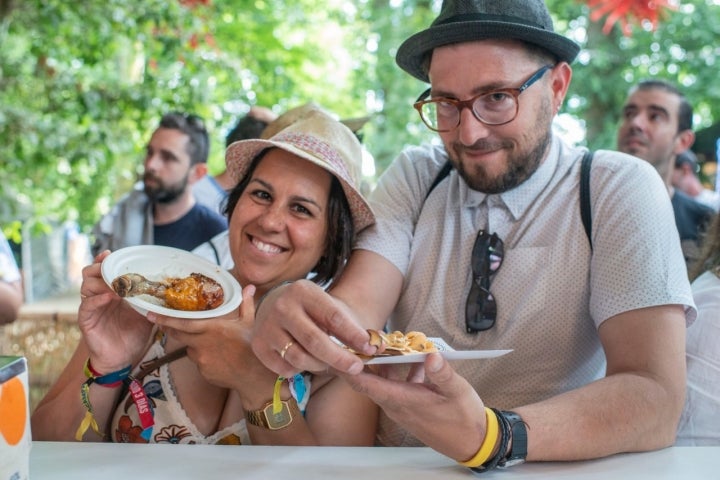 Dos festivaleros probando el pollo indonesio y la tostada de setas zarandeadas.