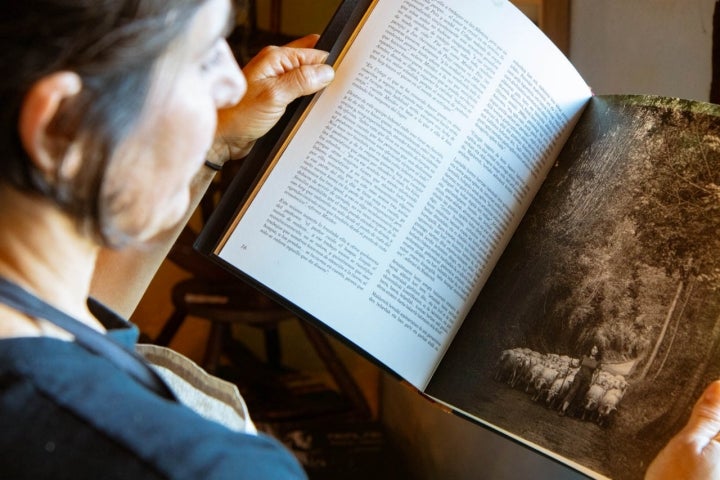 Maider muestra un libro sobre pastores en la sierra de Aralar en el que salieron ellos como la generación que toma el relevo.