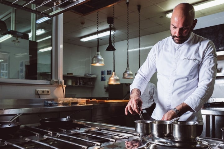 El ayudante de cocina estaba lavando platos en la cocina.