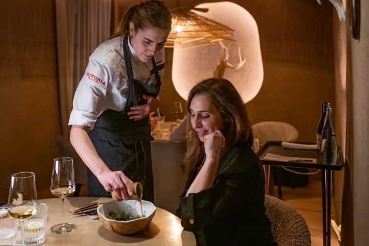 Lucía echando el caldo de cocido sobre el bacalao.