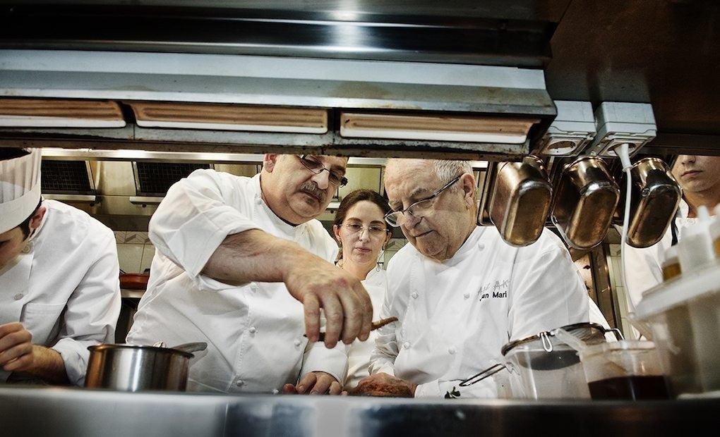 Arzak con su hija Elena y parte de su equipo cocinando.