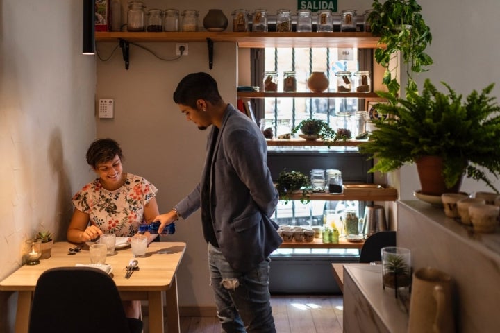 Un camarero sirve agua a una clienta en el restaurante Bichopalo