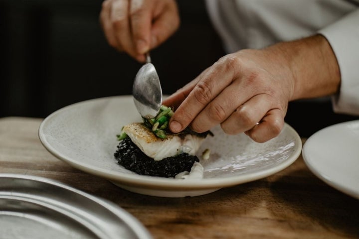 El pescado del día hoy es merluza con arroz negro, calamar y pil pil de ajo tostado y lima.