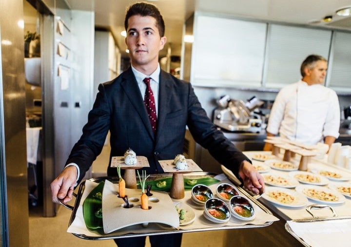 Bandeja con los aperitivos de todos los menús y, al fondo, Nandu Jubany.