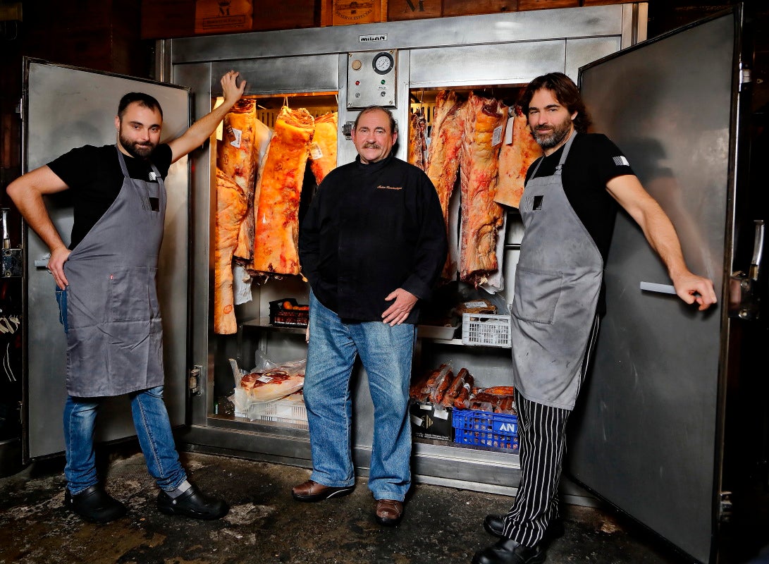 Matías Gorrotxategi y sus dos hijos junto a las neveras repletas de la mejor carne de vacuno para asar en 'Casa Julián', Tolosa.