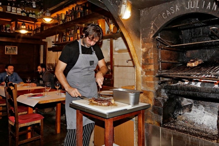 Uno de los hijos de Iñaki cortando la chuleta recién sacado de la parrilla de 'Casa Julián'.