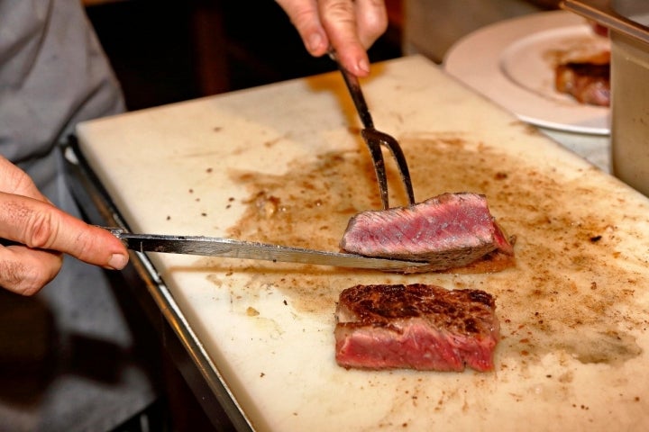 Trinchando la chuleta recién sacada de la parrilla en 'Casa Julián', Tolosa.