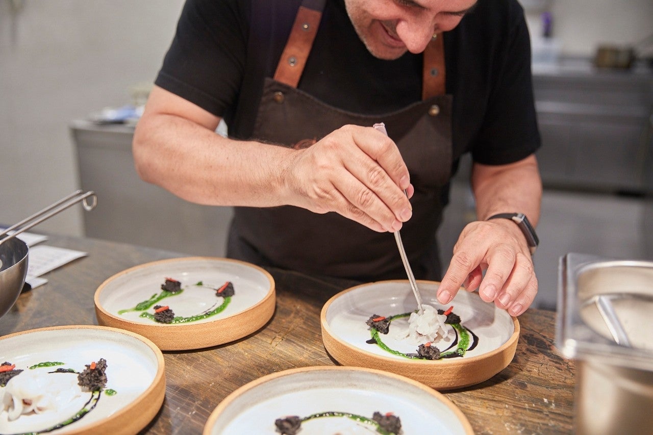 Artal nos da la bienvenida en la cocina mientras prepara uno de los platos del menú.